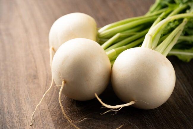 group of white silky sweet turnips on wooden table