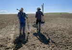 Oregon State University professor Markus Kleber, left, and graduate student Drew Childs collect soil samples from a crop field near Boardman, Ore., in March. They plan to collect samples from 110 sites in Morrow, Gilliam and Sherman counties to build a map of soil carbon potential across the state.