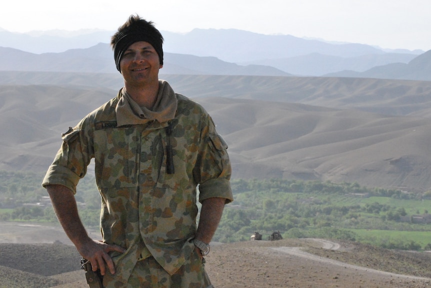 Image of a man in army equipment on top of a hill. 