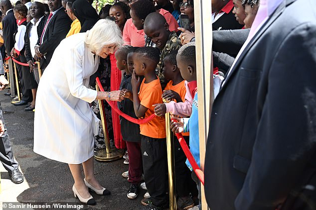Queen Camilla greeting children, during her visit to Eastlands Library, with King Charles III